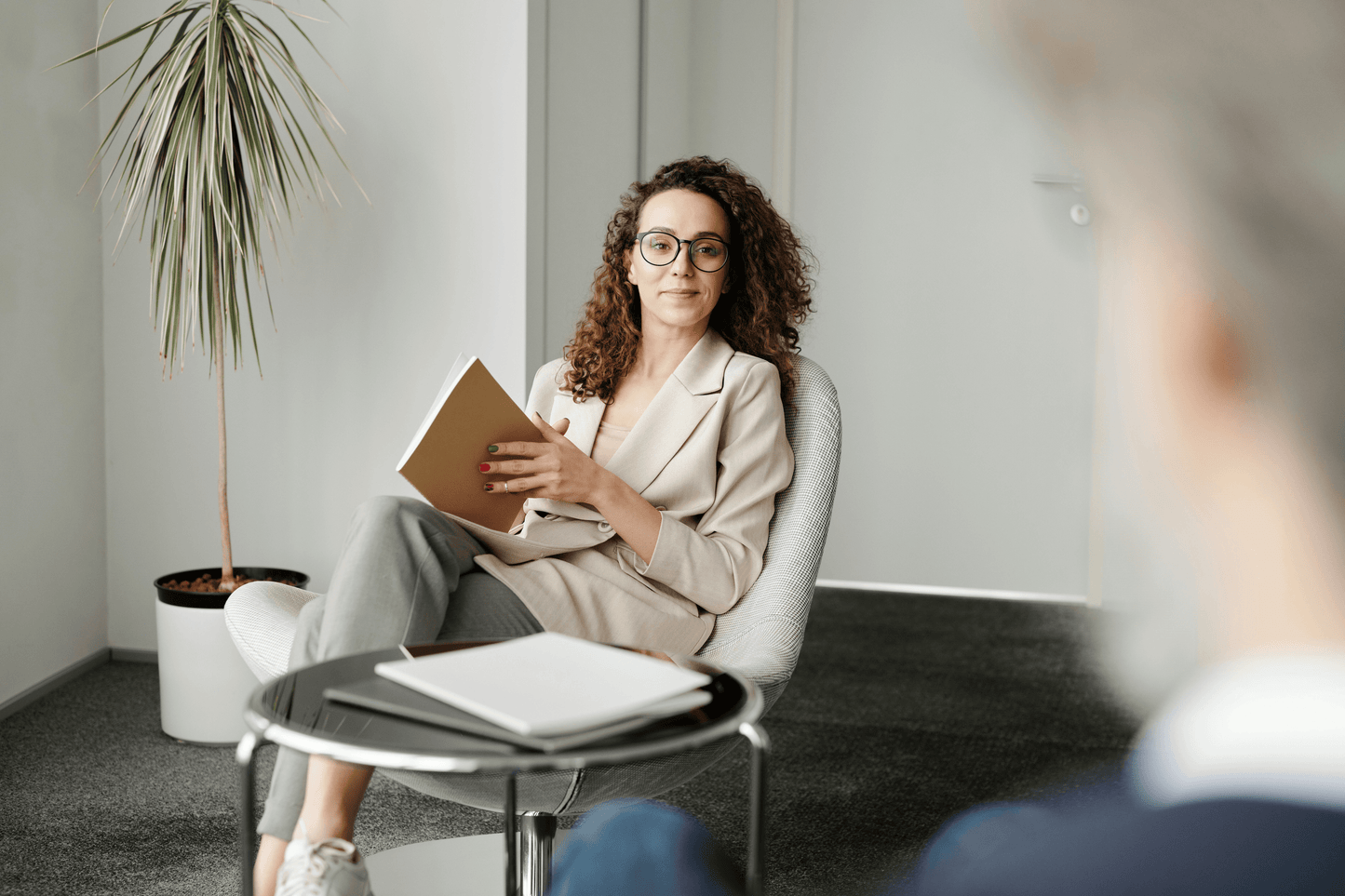 HR consultant in meeting, holding a notebook, discussing strategies for optimizing HR systems.